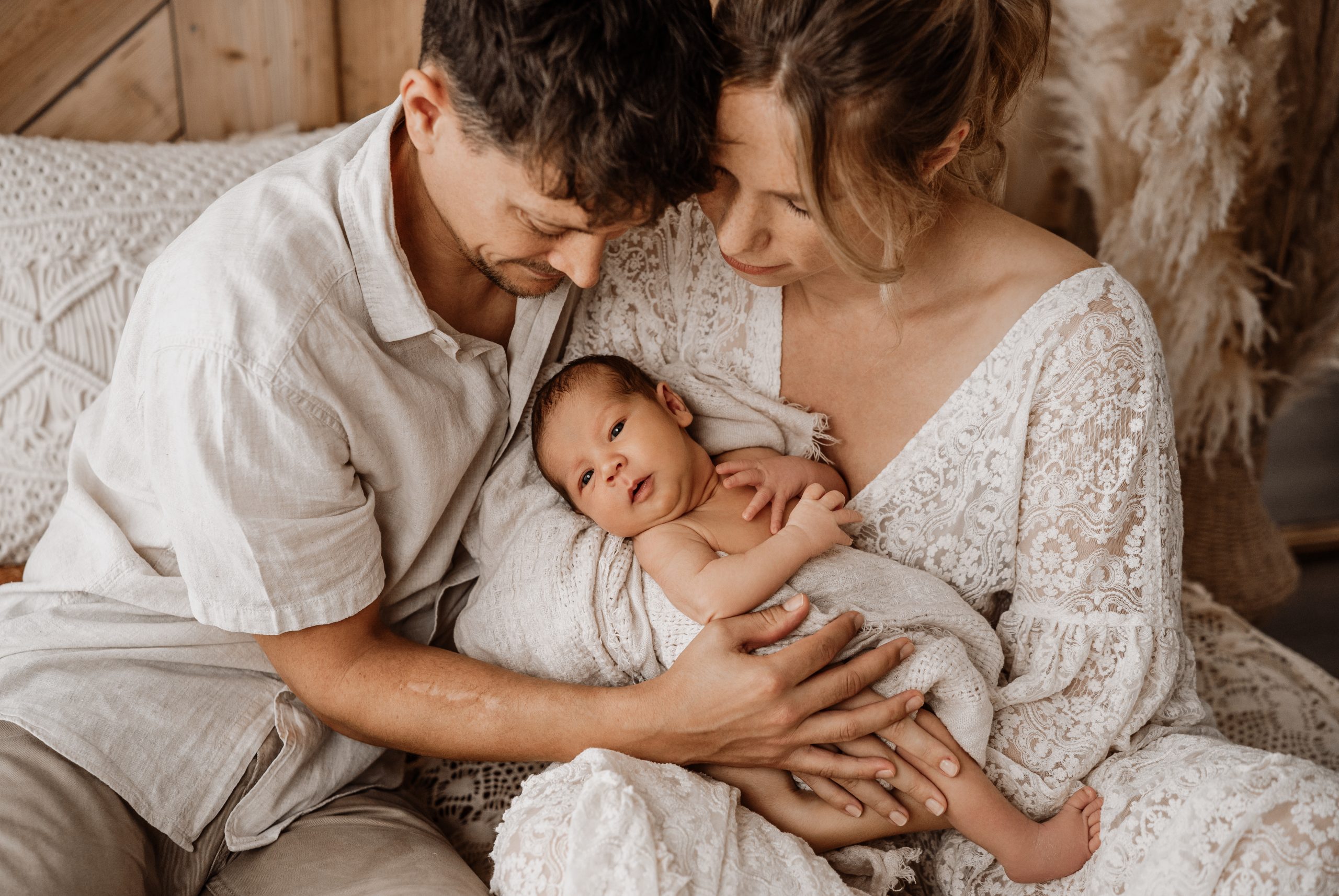 Neugeborenenshooting mit Mama und Papa auf dem Bett